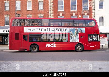 Leerer roter Doppeldecker-Servicebus mit seitlich beworbenen Filmen Stockfoto