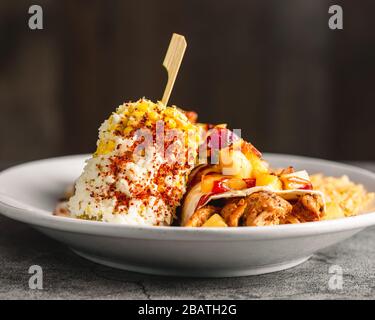 Schön beschichtetes Huhn und Ananasburrito mit Reis und würzigem Mais auf dem Cob 45 Grad Winkelschuss Stockfoto