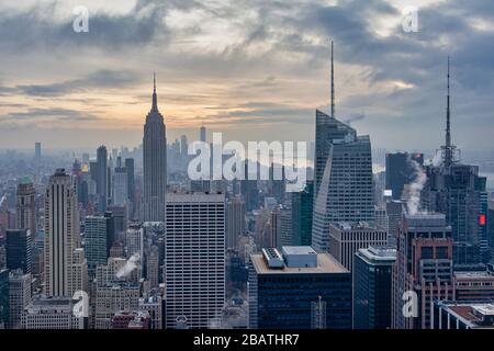 Skyline von New York von der Spitze des Rock (Rockefeller Center)Blick auf den Sonnenuntergang im Winter mit Wolken am Himmel Stockfoto