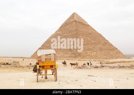 Ein Pferdewagen, der von der Khufu-Pyramide, auch Cheops-Pyramide genannt, auf dem Giza-Plateau in Kairo, Ägypten geparkt wurde. Stockfoto