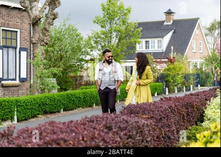 Ein junges Paar spazieren auf einer ruhigen Straße Stockfoto