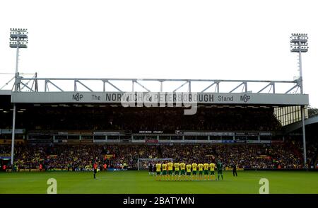 Spieler beobachten vor dem Spiel einen minutenlangen Applaus in Erinnerung an den ehemaligen Norwich City Manager John Bond Stockfoto