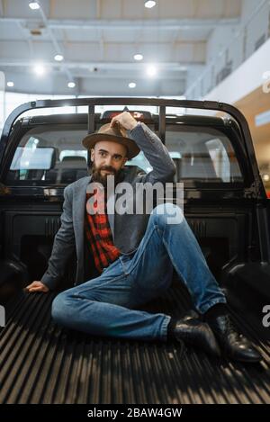 Lächelnder Mann posiert im Rücken des neuen Pickup-Trucks Stockfoto