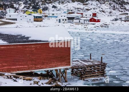 Blick über eine Bühne auf Seal Cove zum Dorf Fogo im Winter, mit Pfannkucheneis, auf Fogo Island, Neufundland, Kanada [keine Immobilien-Releases Stockfoto