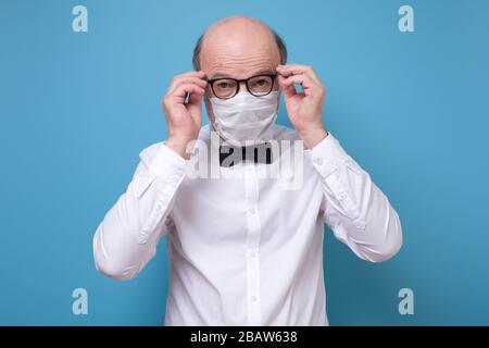 Ernsthafter Mann in spezieller Sanitäter-Maske beim Blick auf die Kamera. Stockfoto