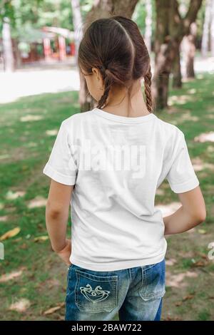 Blick auf das kleine Mädchen in leerem T-Shirt im Park. Mockup für Design Stockfoto