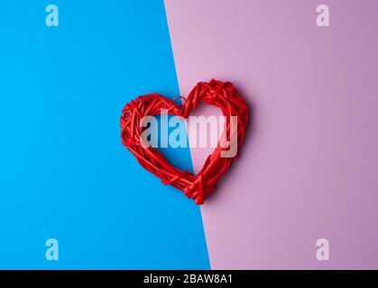 Rotes Korbflechterherz auf blauem Fliesenhintergrund, festliche Kulisse, Draufsicht Stockfoto