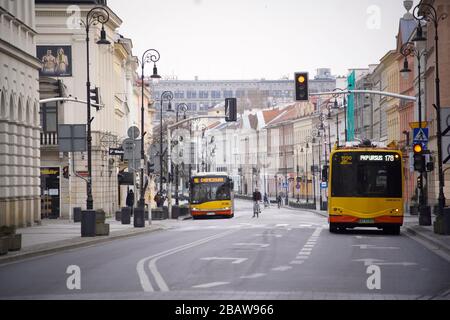 Warschau, Polen. März 2020. Am 29. März 2020 sind auf der Straße Nowy Swiat im Zentrum von Warschau, Polen, nur ein Radfahrer und Busse zu sehen. Am 24. März kündigte die polnische Regierung weitere Einschränkungen der persönlichen Bewegung an, nachdem sie bereits Schulen, Bars und Restaurants geschlossen hatte und die Grenzen zu Ausländern geschlossen hatte. Versammlungen von mehr als zwei Personen sind bis zum 11. April in der Öffentlichkeit verboten. Trotz strengerer Maßnahmen hat die Regierungspartei für Recht und Gerechtigkeit die Wahlregeln so geändert, dass die Präsidentschaftswahlen vom 10. Mai weiterhin stattfinden werden. Kredit: SIPA USA/Alamy Live News Stockfoto