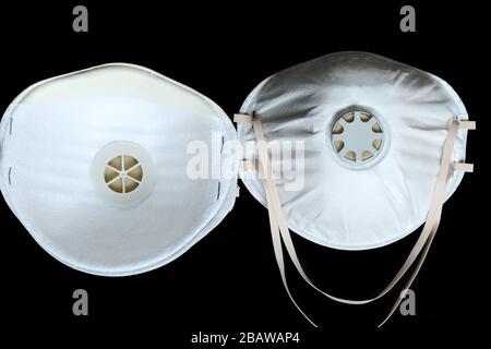 Zwei Schutzmasken für weiße Chirurgie FFP2 zum Schutz vor Virusinfektion Coronavirus COVID-19, isoliert auf schwarzem Hintergrund Stockfoto