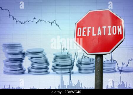 Deflationszeichen auf dem wirtschaftlichen Hintergrund - Grafik und Münzen. Finanzunfall in der Weltwirtschaft wegen Coronavirus. Weltwirtschaftskrise, Rezession. Stockfoto