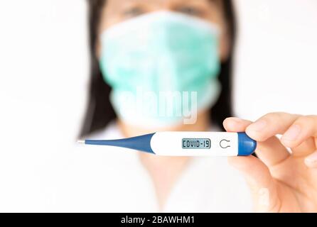 Eine Krankenschwester für Frauen, die Thermometer hält. Medizinisches Konzept des Ausbruchs des Corona-Virus. Stockfoto