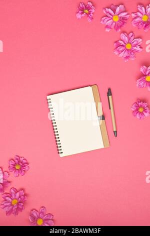 Papiernote mit Blumen auf rosa Hintergrund. Draufsicht. Stockfoto