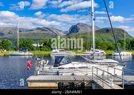 Vergnügungsboote, die in Banavie in der Nähe von Fort William Highland Scotland auf dem Caledonian Canal mit dem berühmten Berg Ben Nevis einen Hintergrund bieten Stockfoto