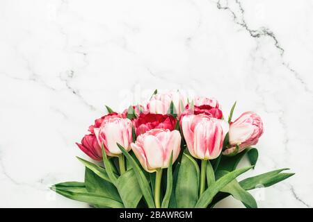 Pink Peony Tulpen auf Marmorhintergrund mit Platz für Text und Design. Muttertag Blumen, Geschenkkonzept für den Frauentag Stockfoto