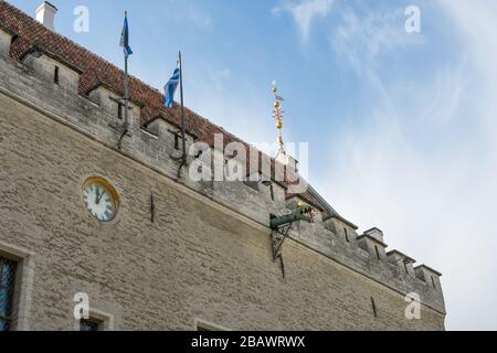 Einer der Drachenkopf Wasserspeier ragt in der Nähe der Uhr auf dem mittelalterlichen Rathausgebäude in Tallinn Estland aus. Stockfoto