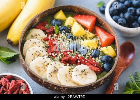 Vegane Superfood-Smoothie mit verschiedenen Belägen in Kokospüssel-Nahaufnahme Stockfoto