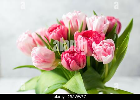 Blumenstrauß mit schönen rosafarbenen Ponytulpen auf grauem Hintergrund. Nahansicht Stockfoto