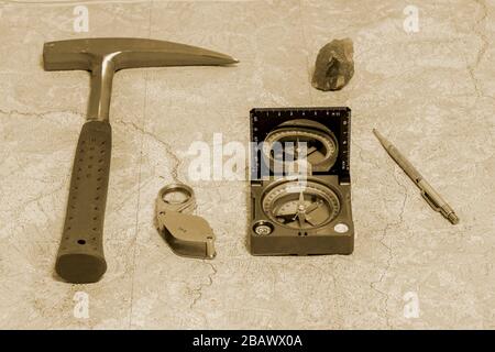 Die Werkzeuge der Geologe auf einer topographischen Karte. Hintergrund. Toning. Stockfoto