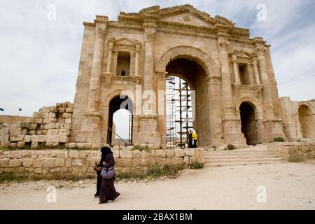 Jerash, Jordanien - 2. Mai 2009: Frauen passieren den alten römischen Hadriansbogen in der antiken Stadt Gerasa in Jerash, Jordanien. Stockfoto