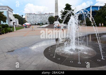 TUAPSE, RUSSIA-CIRCA JUL, 2018: Sommerbrunnen und Granit-Stele befinden sich auf einer Straße, die nur zu Fuß zu erreichen ist, auf dem Platz der Oktoberrevolution. Mitte des Resors Stockfoto