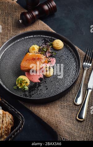 Gebratenes Schweinekotelett, Kartoffelpüree auf einem schönen Teller, serviert auf dem Tisch. Food Foto, Kopierbereich, grauer Hintergrund. Stockfoto