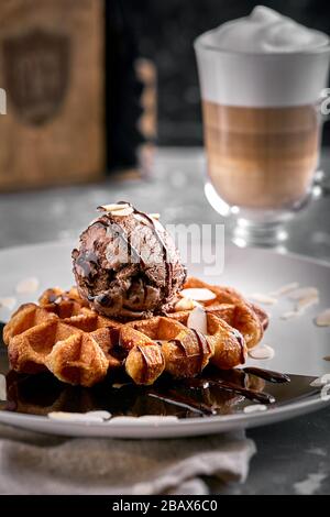Wiener Waffeln mit Eis und Kaffee. Wunderschönes Dessertbild mit Lettenkaffee. Dessertkonzept, süßes Leben. Lebensmittelfoto, Kopierbereich, grau Stockfoto