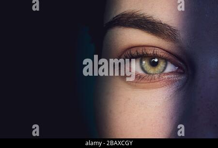 Augen spionieren Konzept durch Loch vor dunklem Hintergrund Stockfoto