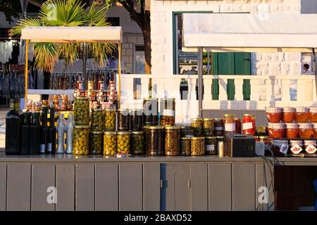 Verschiedene Glasgefäße aus hausgemachtem eingelegtem oder fermentiertem farbenfrohem Gemüse und Marmeladen in den Regalen auf dem lokalen Markt. Fermentiertes Lebensmittelkonzept Stockfoto