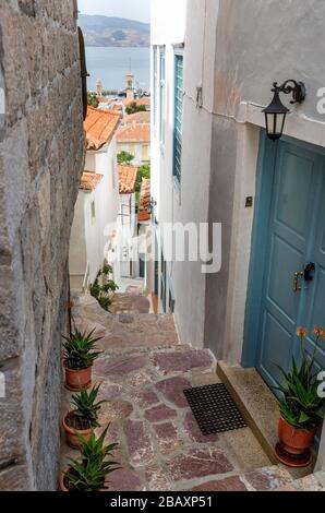 Steiler und enger Gehweg zwischen Wohnungen und Wohnhäusern auf der griechischen Insel Hydra, Griechenland. Stockfoto