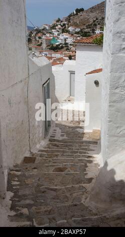 Steiler und enger Gehweg zwischen Wohnungen und Wohnhäusern auf der griechischen Insel Hydra, Griechenland. Stockfoto