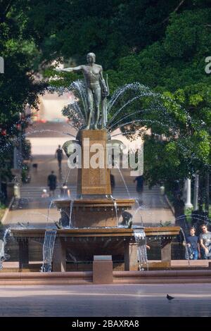 Der Archibald Fountain befindet sich im Hyde Park in Sydney, Australien. Benannt ist es nach J.F. Archibald, der Gelder vermachte, um sie bauen zu lassen. Archibald legte fest, dass es von einem französischen Künstler aufgrund seiner großen Liebe zur französischen Kultur entworfen werden muss und um der Vereinigung Australiens und Frankreichs in WW1 zu gedenken. Er wünschte, Sydney strebe nach Pariser Civic Design und Ornamentik. Als Künstler ausgewählt wurde François-Léon Sicard, der es 1926 in Paris fertigstellte, aber nie sah, wie die Skulptur in Sydney aufgestellt wurde, wo sie im März 1932 vom Oberbürgermeister von Sydney, Samuel Walder, enthüllt wurde. Stockfoto