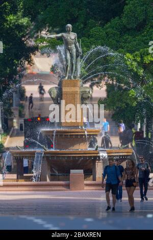 Der Archibald Fountain befindet sich im Hyde Park in Sydney, Australien. Benannt ist es nach J.F. Archibald, der Gelder vermachte, um sie bauen zu lassen. Archibald legte fest, dass es von einem französischen Künstler aufgrund seiner großen Liebe zur französischen Kultur entworfen werden muss und um der Vereinigung Australiens und Frankreichs in WW1 zu gedenken. Er wünschte, Sydney strebe nach Pariser Civic Design und Ornamentik. Als Künstler ausgewählt wurde François-Léon Sicard, der es 1926 in Paris fertigstellte, aber nie sah, wie die Skulptur in Sydney aufgestellt wurde, wo sie im März 1932 vom Oberbürgermeister von Sydney, Samuel Walder, enthüllt wurde. Stockfoto