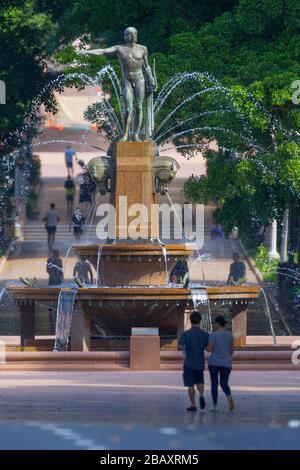 Der Archibald Fountain befindet sich im Hyde Park in Sydney, Australien. Benannt ist es nach J.F. Archibald, der Gelder vermachte, um sie bauen zu lassen. Archibald legte fest, dass es von einem französischen Künstler aufgrund seiner großen Liebe zur französischen Kultur entworfen werden muss und um der Vereinigung Australiens und Frankreichs in WW1 zu gedenken. Er wünschte, Sydney strebe nach Pariser Civic Design und Ornamentik. Als Künstler ausgewählt wurde François-Léon Sicard, der es 1926 in Paris fertigstellte, aber nie sah, wie die Skulptur in Sydney aufgestellt wurde, wo sie im März 1932 vom Oberbürgermeister von Sydney, Samuel Walder, enthüllt wurde. Stockfoto