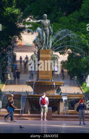 Der Archibald Fountain befindet sich im Hyde Park in Sydney, Australien. Benannt ist es nach J.F. Archibald, der Gelder vermachte, um sie bauen zu lassen. Archibald legte fest, dass es von einem französischen Künstler aufgrund seiner großen Liebe zur französischen Kultur entworfen werden muss und um der Vereinigung Australiens und Frankreichs in WW1 zu gedenken. Er wünschte, Sydney strebe nach Pariser Civic Design und Ornamentik. Als Künstler ausgewählt wurde François-Léon Sicard, der es 1926 in Paris fertigstellte, aber nie sah, wie die Skulptur in Sydney aufgestellt wurde, wo sie im März 1932 vom Oberbürgermeister von Sydney, Samuel Walder, enthüllt wurde. Stockfoto