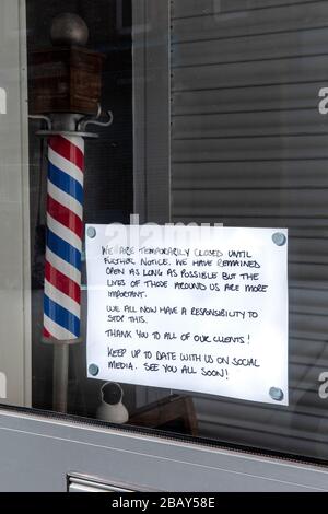 Geschlossenes Schild im Schaufenster, das auf die Einhaltung der britischen Regierungsrichtlinie hinweist, dass alle nicht essentiellen Geschäfte während des Ausbruchs von Coronavirus 2020 geschlossen werden müssen. Stockfoto