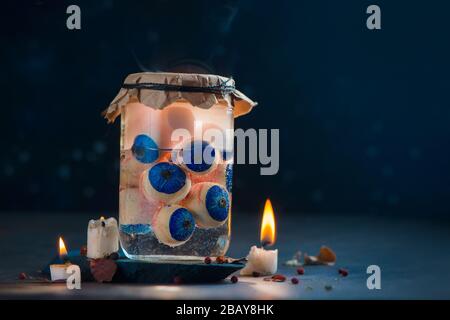 Glasbecher mit Augäpfeln, verspotterter Halloween-Header mit Kerzen Stockfoto