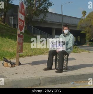 Los Angeles, Kalifornien, USA. März 2020. Los Angeles, Vereinigte Staaten. März 2020. Ein Mann, der eine Maske spendet, hält am Sonntag, den 29. März 2020, einen Sing mit der Bitte um Hilfe auf einer Auffahrt 101 im Gebiet des Silver Lake von Los Angeles. Foto von Jim Ruymen/UPI Credit: UPI/Alamy Live News Credit: UPI/Alamy Live News Stockfoto