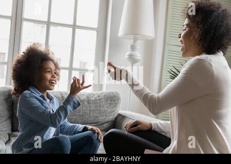 Afrikanische kleine Tochter, die Zeichensprache verwendet, kommuniziert mit der Mutter Stockfoto