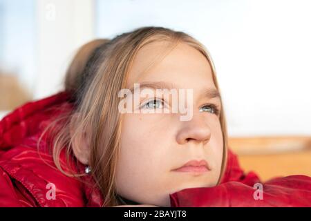 Nahaufnahme Portrait des jungen blonden Grünäugigen Mädchen. Sie legte ihr Kinn wehmütig und penibel auf einen nach oben blickenden Arm. Die Jugend ist voller Ideen, pl Stockfoto