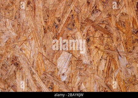 OSB Platten sind aus braunem Holz Chips in einem hölzernen Hintergrund geschliffen. Blick von oben auf die OSB holz furnier Hintergrund, straff, nahtlose Flächen Stockfoto