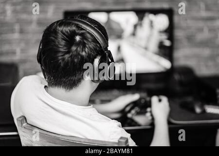 Technologie-, Gaming-, Unterhaltungs- und Personkonzept - junger Mann in Headset und Brille mit pc-Computer, der zu Hause und beim Streamen spielt Stockfoto