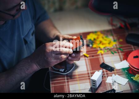 Man Hands Reparatur machen kaputte tv-Fernbedienung Stockfoto