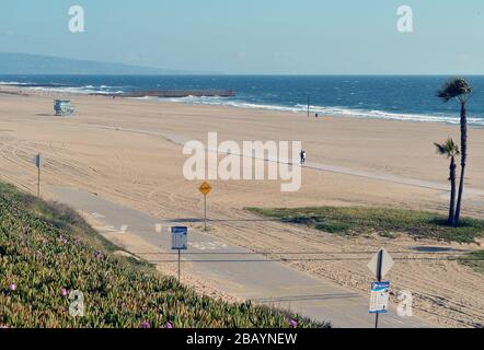 Los Angeles, Kalifornien, USA. März 2020. Los Angeles, Vereinigte Staaten. März 2020. Ein Paar spaziert am Sonntag, 29. März 2020, auf einem menschenleeren Dockweiler State Beach in Los Angeles. Der Bürgermeister von Los Angeles Eric Garcetti erließ am Donnerstag einen "Safe at Home"-Befehl, in dem die Bewohner aufgefordert wurden, zu Hause zu bleiben und alle "nicht wesentlichen Aktivitäten" zu begrenzen. Foto von Jim Ruymen/UPI Credit: UPI/Alamy Live News Credit: UPI/Alamy Live News Stockfoto