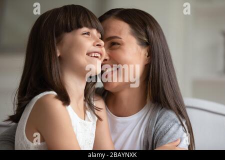 Fröhliche junge Mutter hat Spaß beim Spielen mit kleiner Tochter Stockfoto