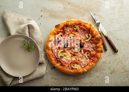 Pizza mit Mozzarella Käse, Schinken, Pilzen und Tomaten Sauce Stockfoto