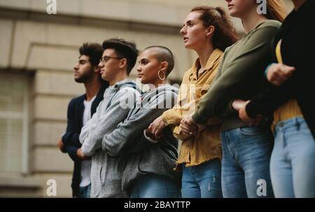 Gruppe von Aktivisten, die sich zusammenhalten, um die Hände im Protestpocket zu halten. Demonstranten protestieren lautlos. Stockfoto