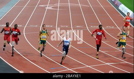 Der britische Jonnie Peacock (4. Links) überwindet die Linie, um bei den Paralympischen Spielen in London das 100-m-T44-Finale der Männer zu gewinnen. Stockfoto