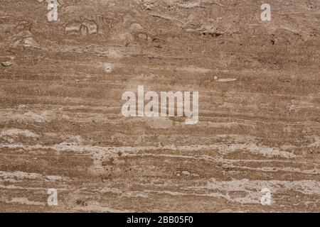 Brauner natürlicher Travertin-Steinplattenhintergrund aus nächster Nähe. Stockfoto