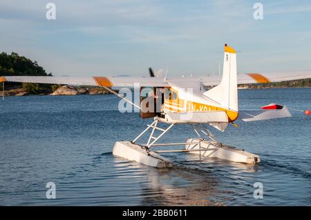 Ein gelb-weißes Wasserflugzeug der Cessna 172 Skyhawk, das zum Start zwischen den Inseln des Archipels Kragerø an der Südküste Norwegens abflog. Stockfoto