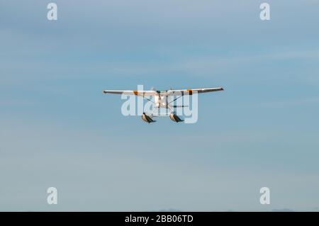 Ein gelb-weißes Wasserflugzeug Cessna 172 Skyhawk, das zwischen Inseln im Archipel Kragerø an der Südküste Norwegens abflog. Stockfoto